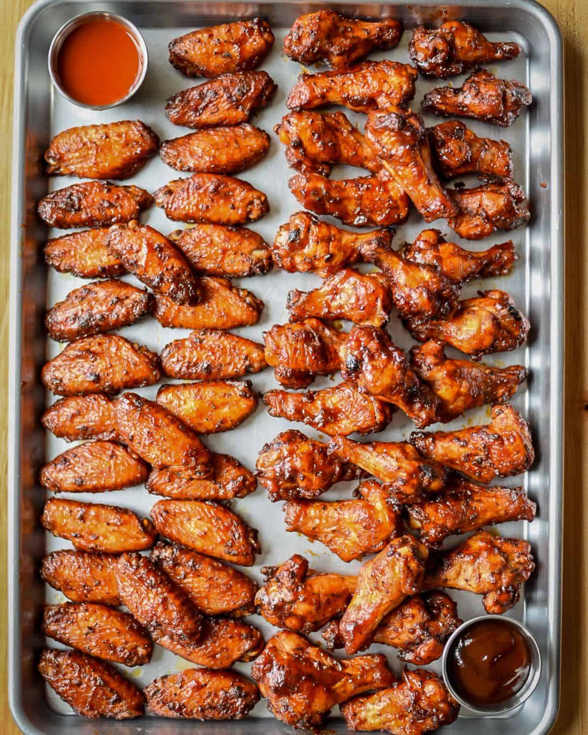A sheet pan with chicken wings. Two rows are flats, and two rows are drums.