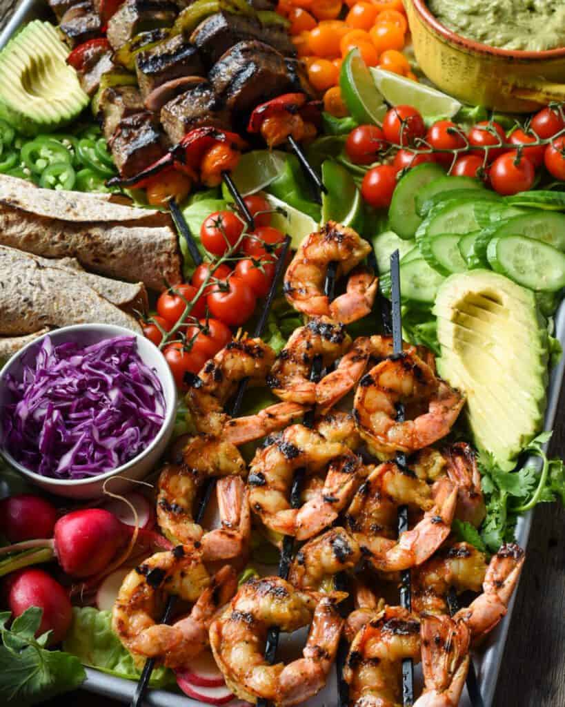 Surf and turf skewers on a tortilla platter with all the fixings.