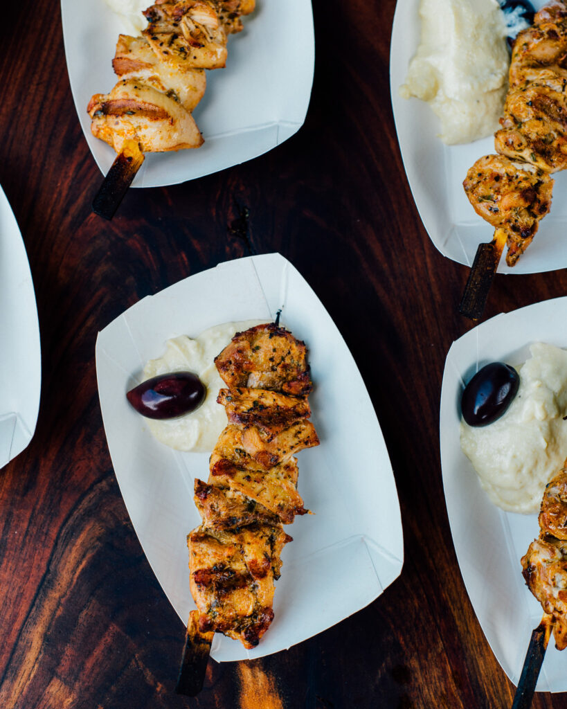 Grilled Chicken Souvlaki with Hummus-Yogurt Dip served in paper boats for a summer bbq.