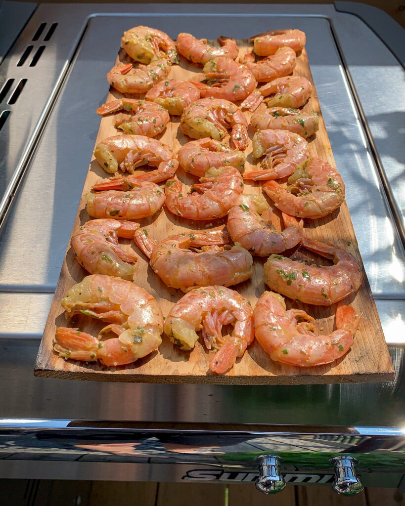 Raw shrimp on cedar plank ready to go on the grill.