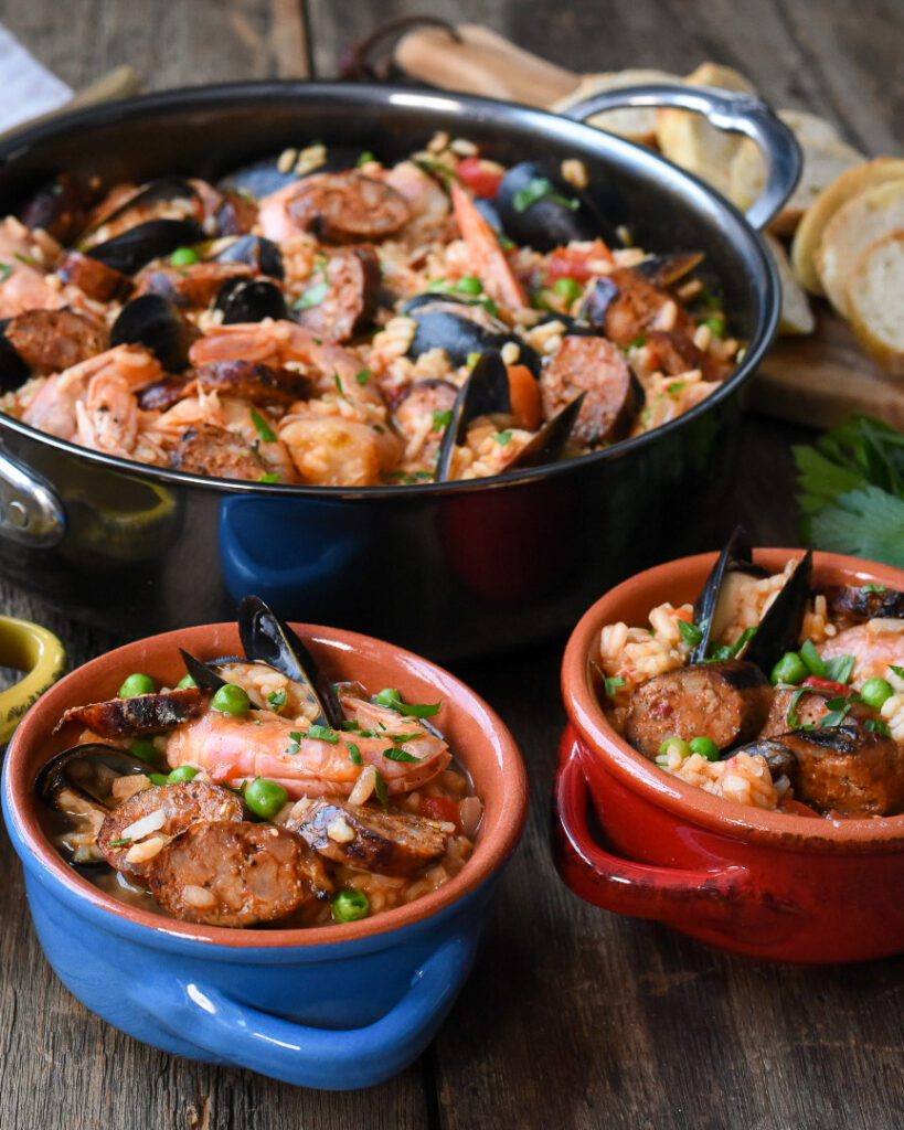 A skillet and two bowls of Hot Italian Sausage Quick, Easy & Affordable Paella