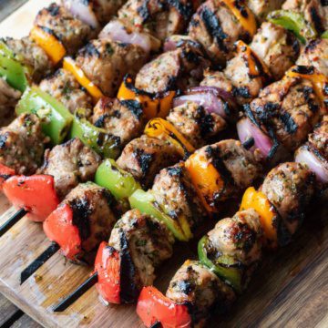 A close up of grilled pork and vegetable skewers.