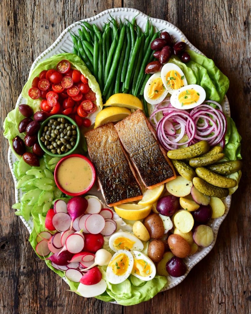 A large colourful platter of a salmon Niçoise-Style Salad. 