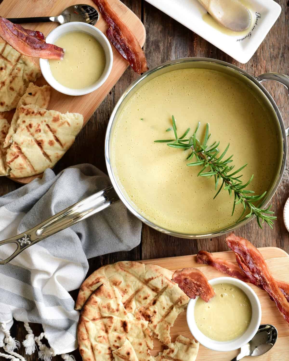 Leed and potato soup served in cups and garnished with a piece of bacon.