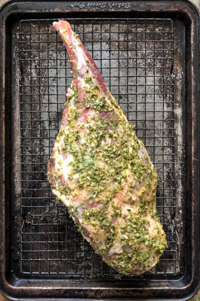 A leg of lamb on prepared wire  rack and sheet pan.