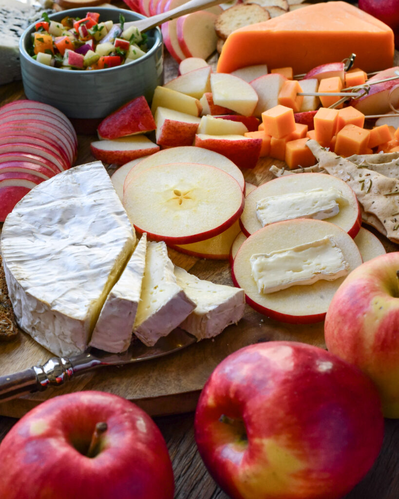 a close up of Ambrosia apple slices with Brie on a cheese board. 