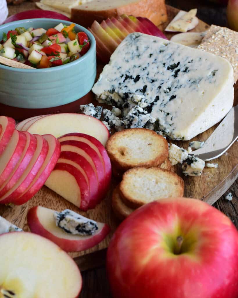 A close up of Honeycrisp apple slices and blue cheese on a cheese board.