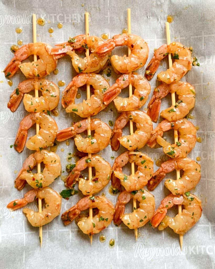 Four shrimp skewers, with five shrimp on each skewers.
