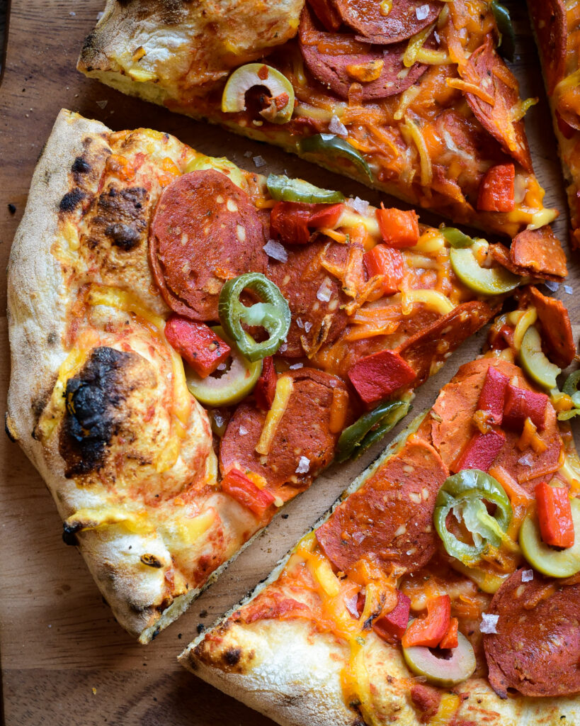 A close up image of a plant-based pepperoni pizza slices, 