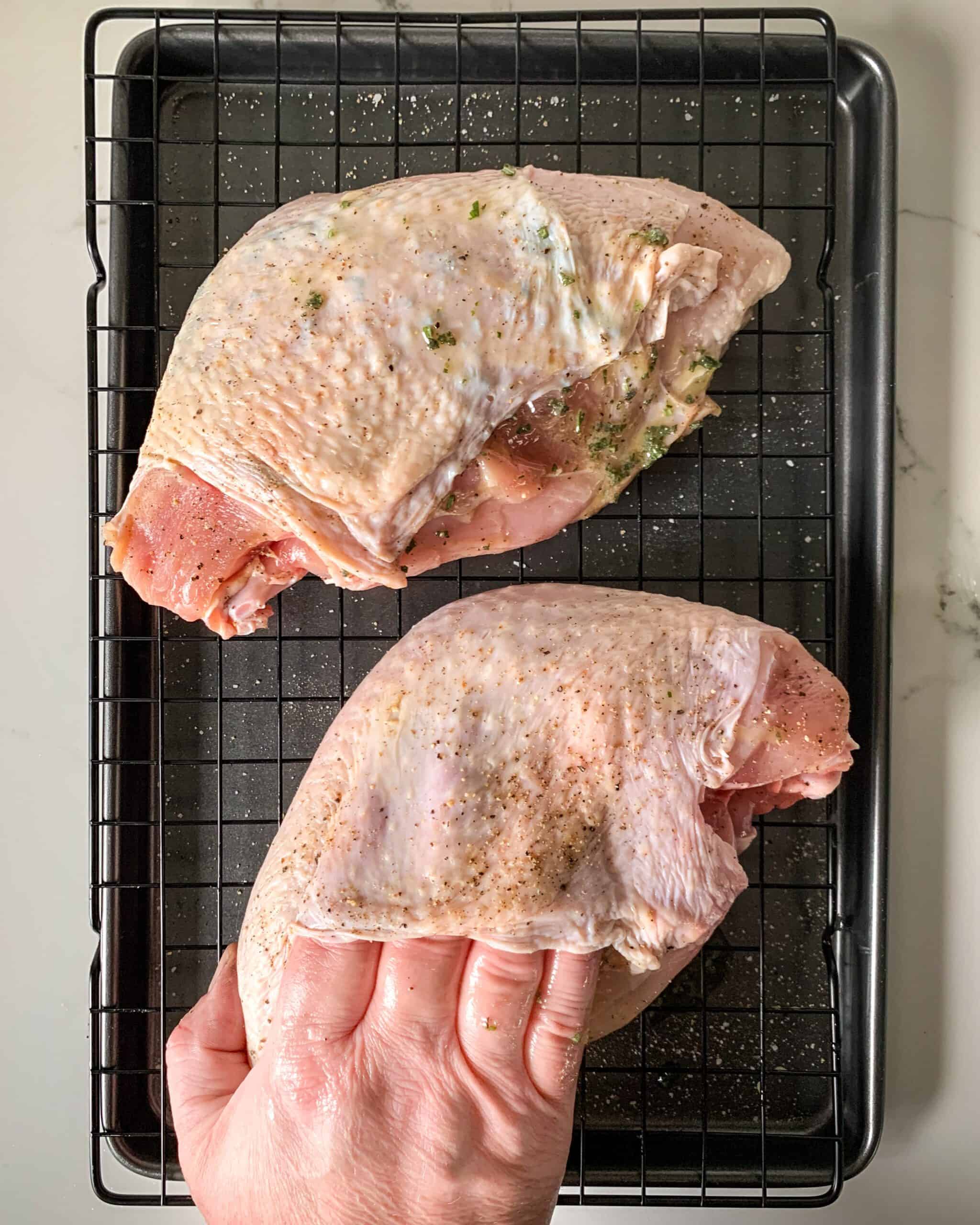 Rubbing the turkey breast with butter under the skin.