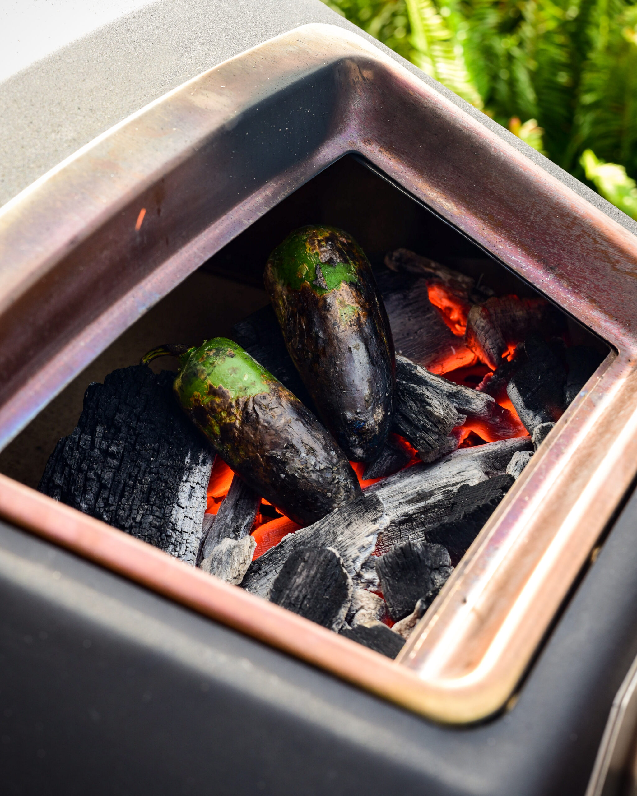Charring jalapeños directly on the coals