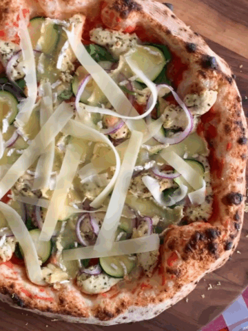 A close up of a Lemon-Rosemary Chicken Pizza with cheese strips.