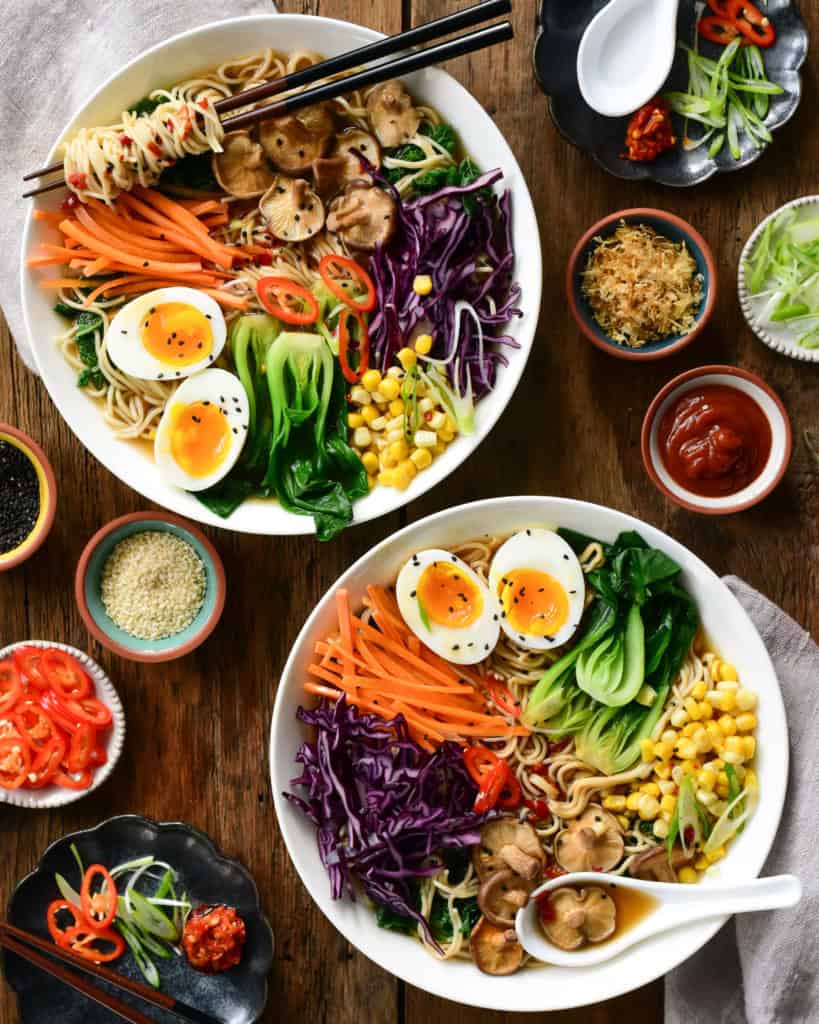 This image shows two bowls of ramen and how all the ingredients are placed in the bowl.