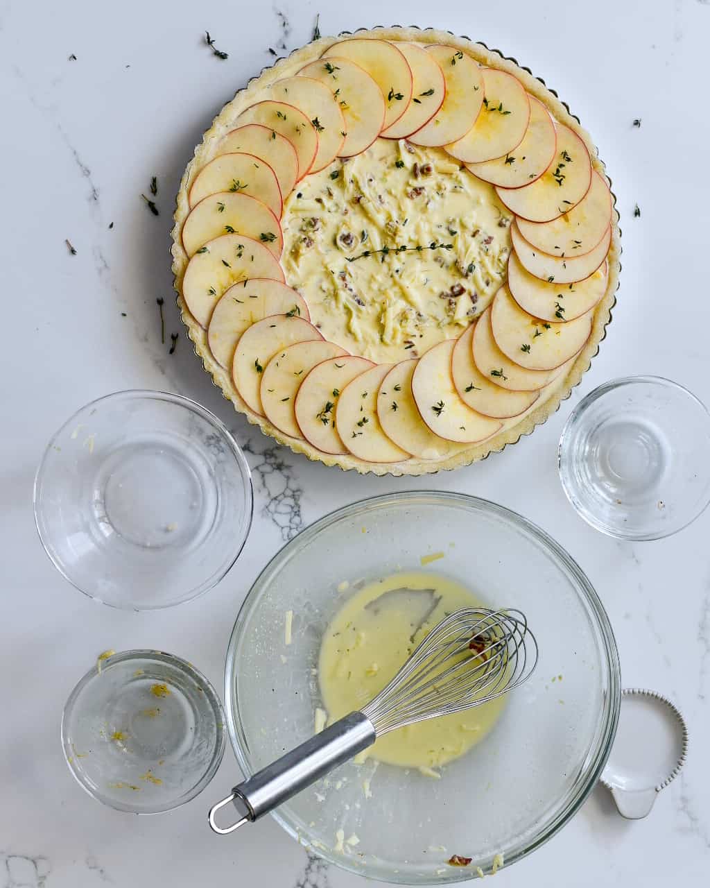 Layer the Ambrosia apple slices, to create a single circle around the outside of the quiche near the crust. Overlap each slice by about half. 