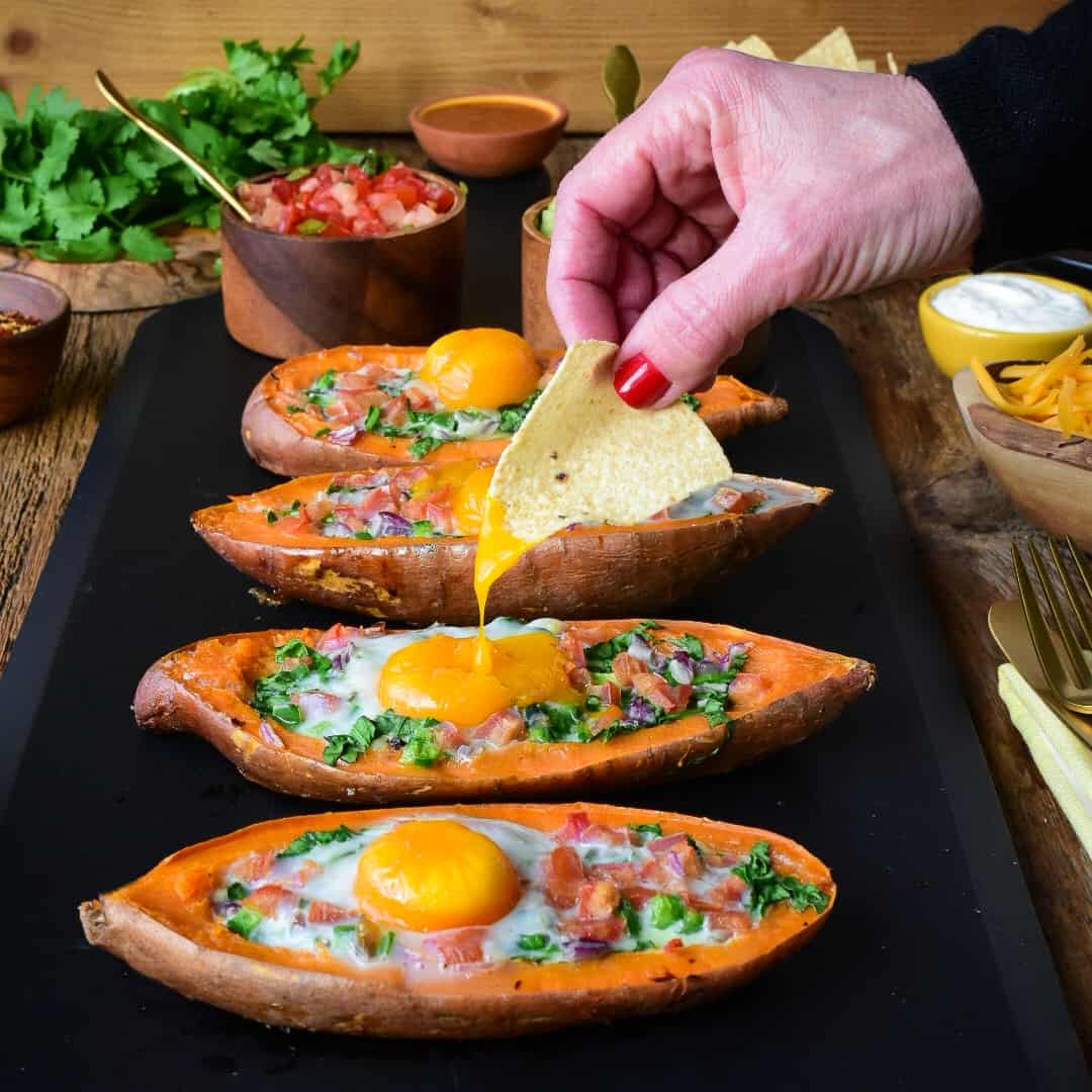 This shows a nacho getting dipped into the yolk on the sweet potato boat.