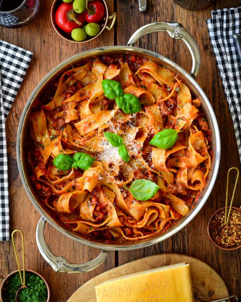 A pot of spicy Italian sausage ragu with pappardelle pasta.