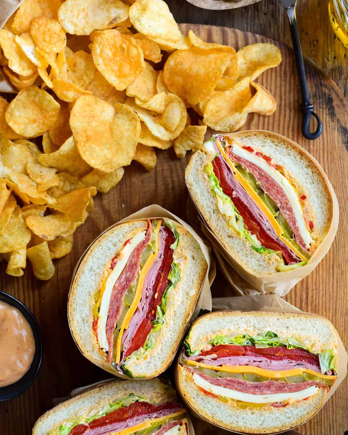 Stuffed sandwich halves reveal the layers of varieties of meat and cheese.