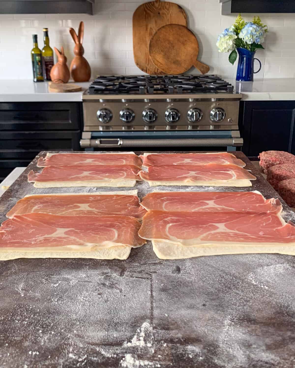 Lay 2 pieces of prosciutto onto each puff pastry square.