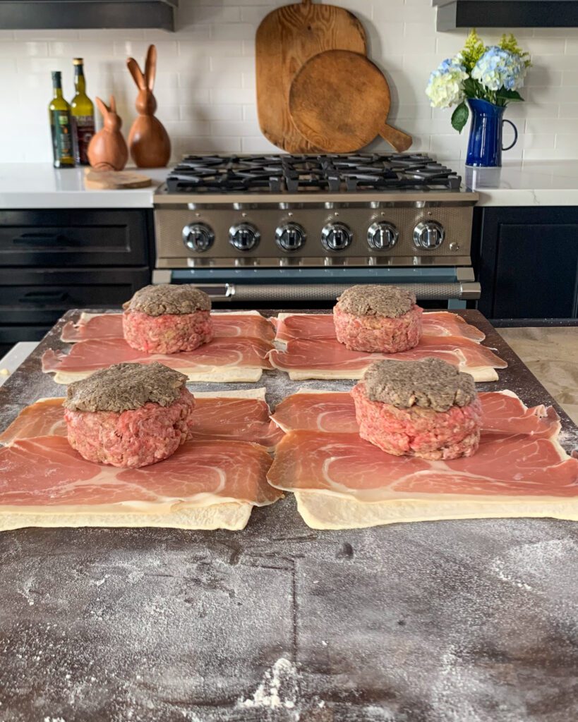 Add one portion of the mushroom mixture on top of each beef patty and flatten out into an even layer.
