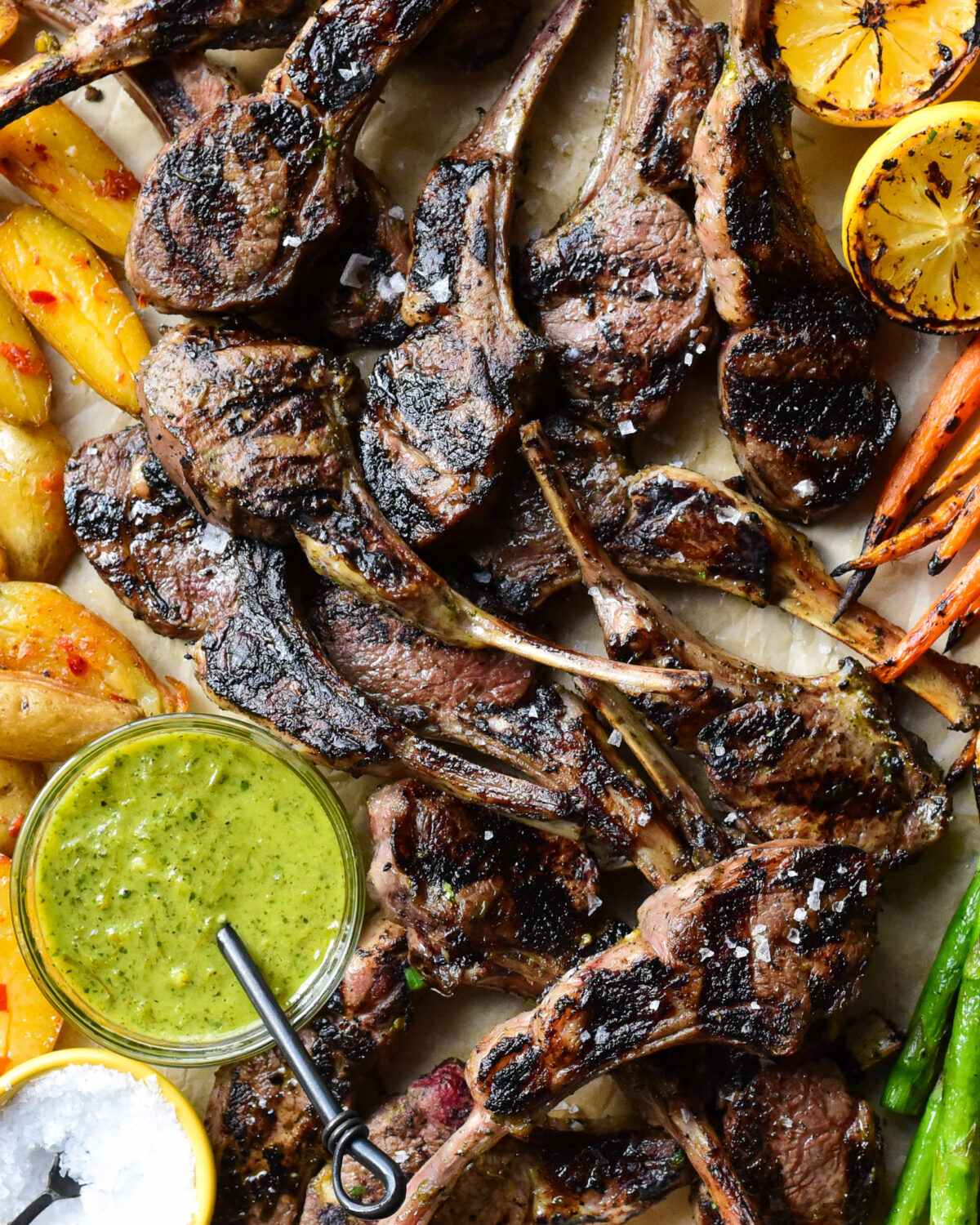 Close up of lamb chops with a green sauce.