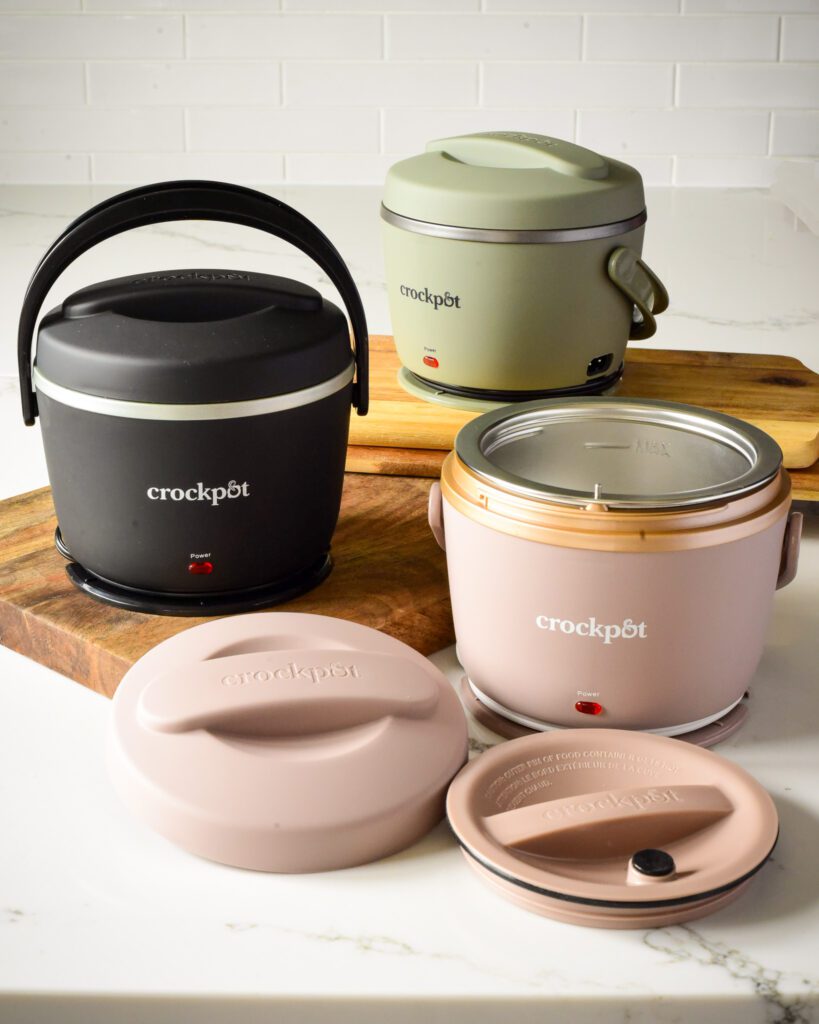 A black, green and pink Crockpot™ Lunch Crocks. They have a handle and two lids.