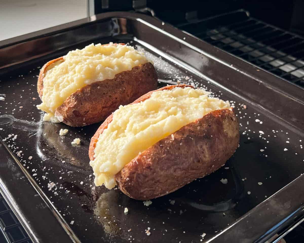 Two twice-baked potatoes going into the air fryer.