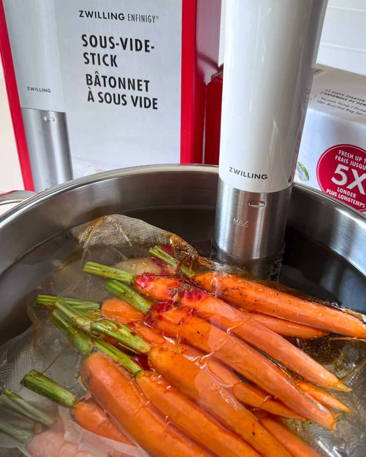 A vacuumed sealed bag of carrots in a water bath.