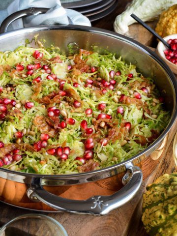 A copper pan with Shredded Brussels Sprouts with Pine Nuts, Pancetta and pomegranate arils.