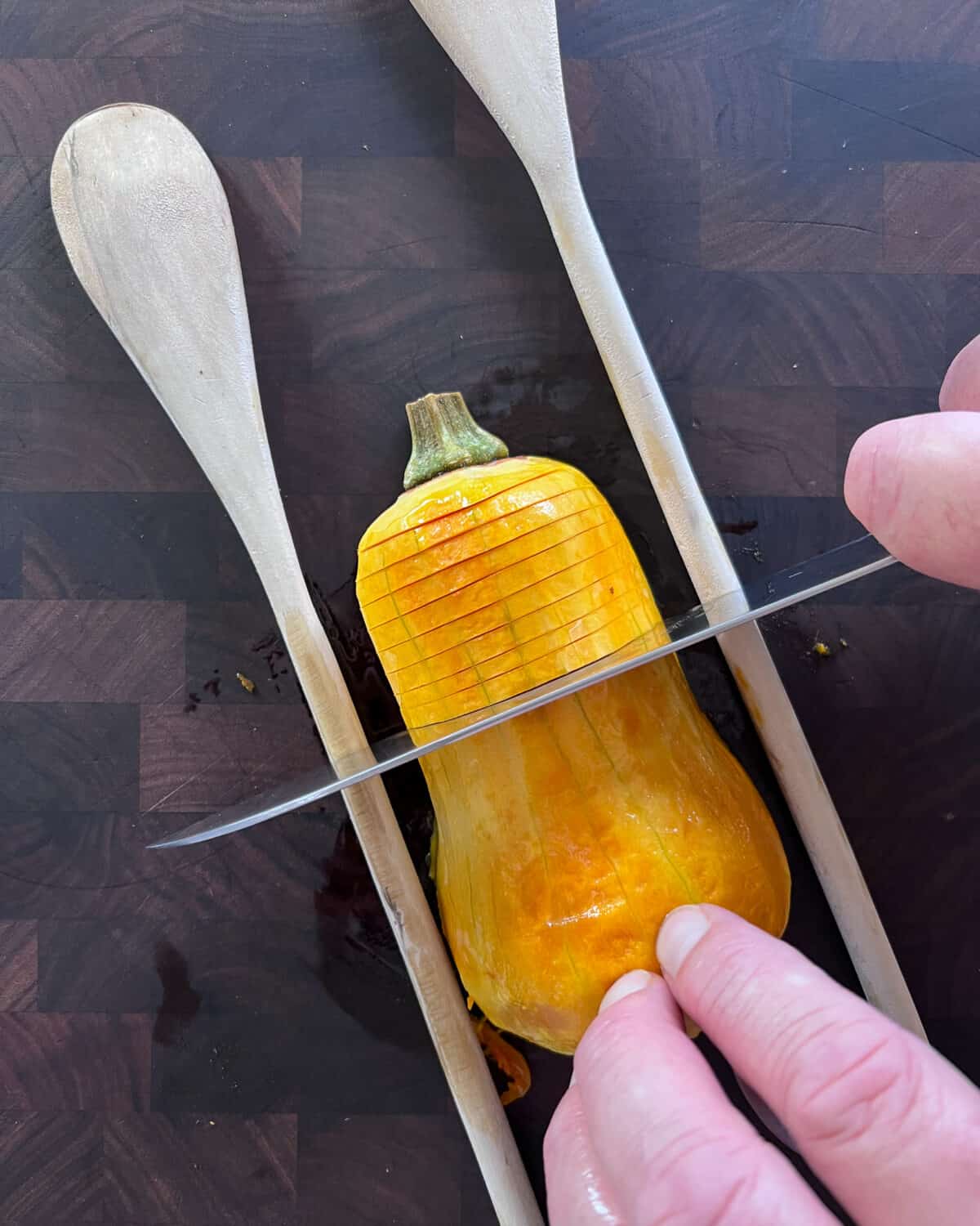 Tip: When slicing the squash to create “Hasselbacking”, use two wooden spoons to keep the squash from rolling and prevent the knife from cutting all the way through.