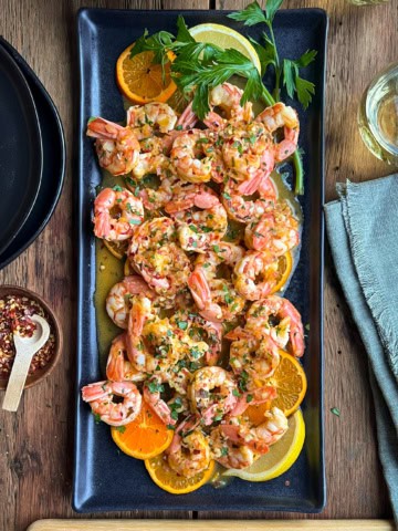 A citrus shrimp dish with clementine and lemon slices.