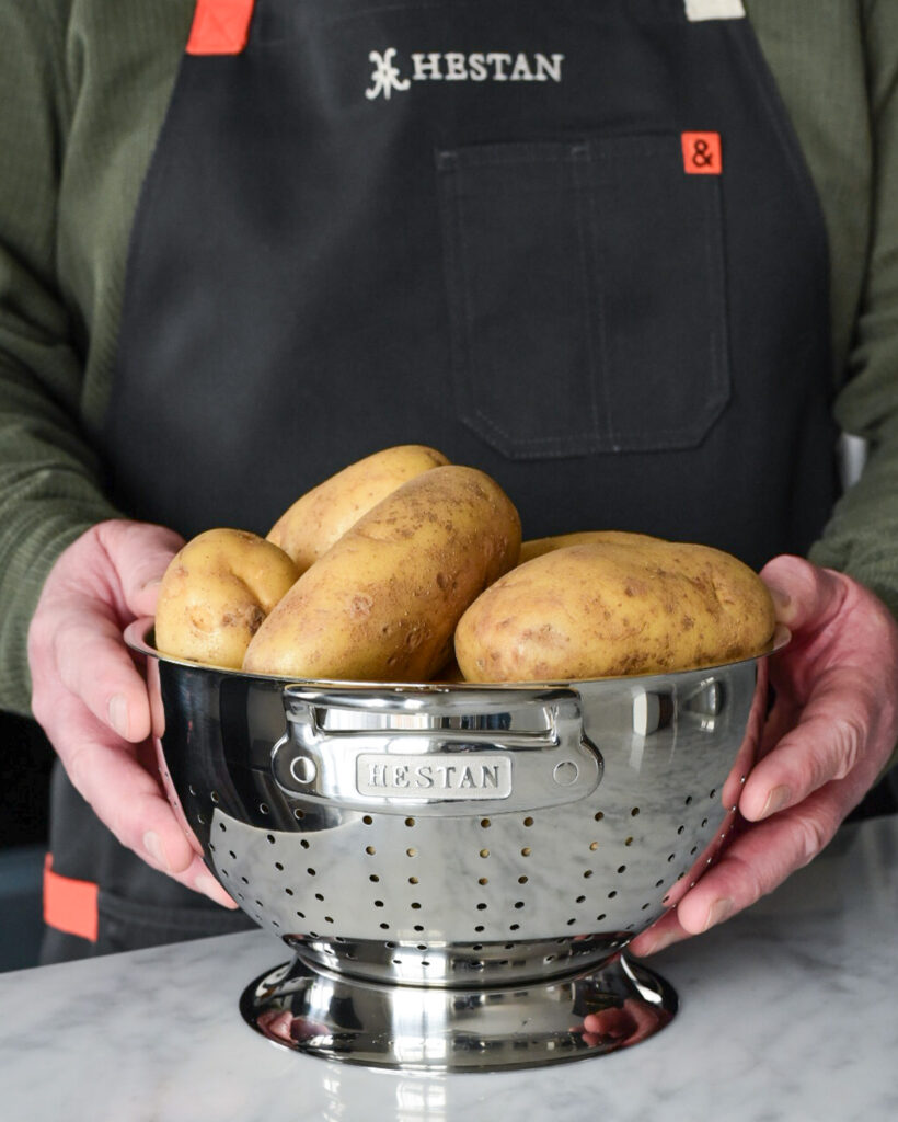 A stack of potatoes in a Hestan colander.