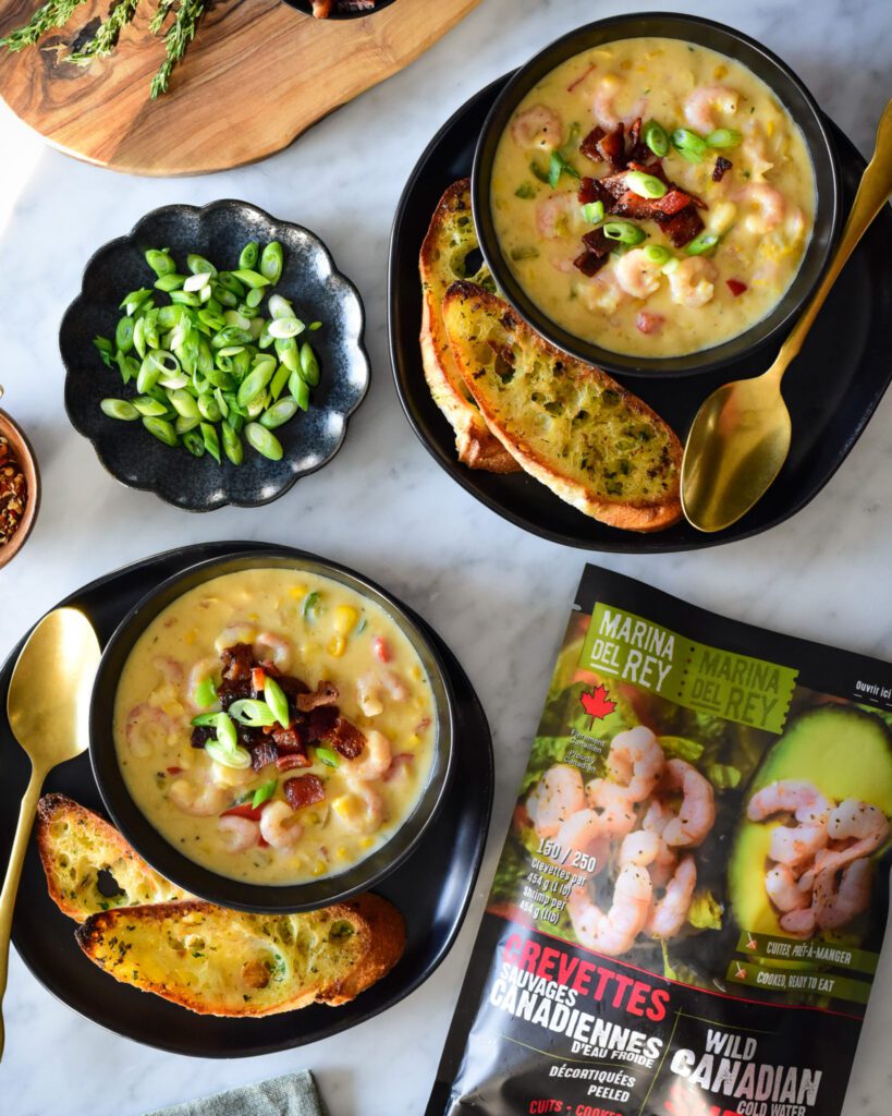 Two bowls of Shrimp & Corn Chowder with herbed butter baguette toasts plus a bag of frozen shrimp.