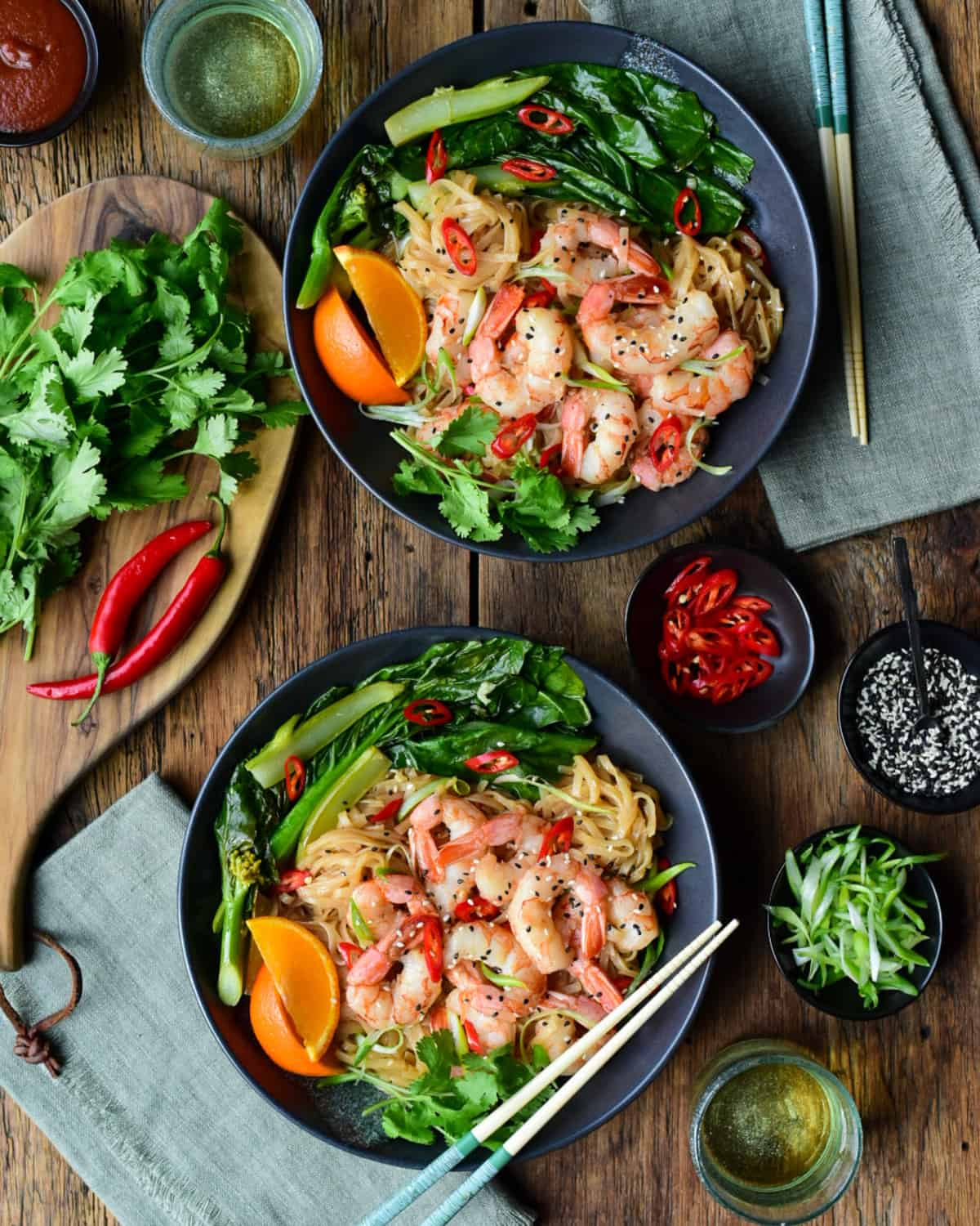 Two Spicy Shrimp Noodle Bowls served with Chinese broccoli and Minneola orange wedges.