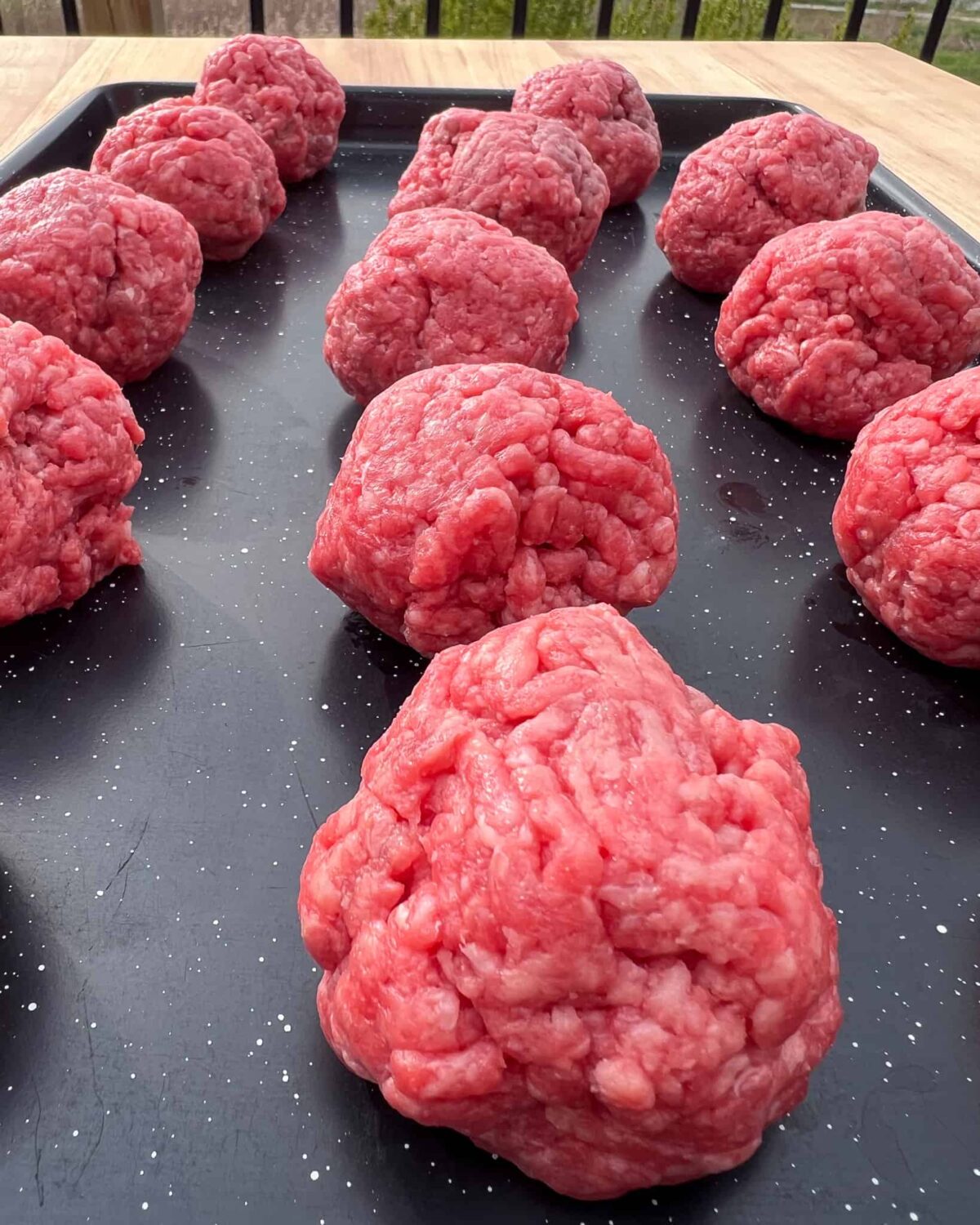 Roll the ground beef into 3 ounce balls and place on a sheet pan.