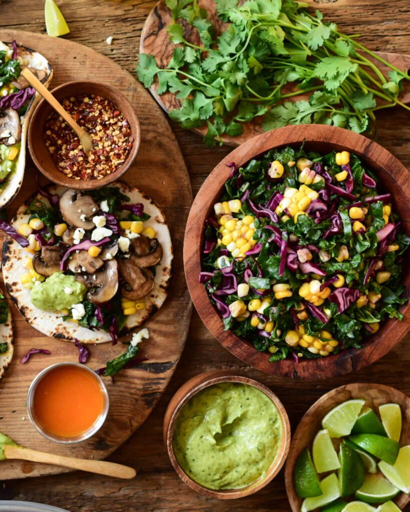 A bowl of Kale-Cabbage-Corn Slaw and Charred Jalapeño Crema on a mushroom taco board.