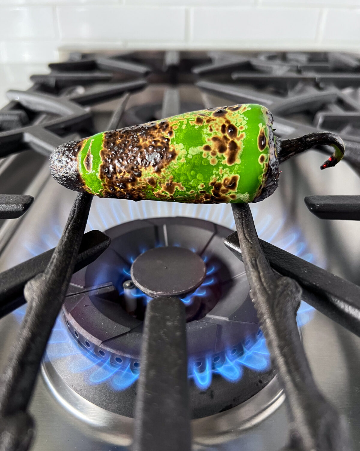 Char the jalapeño directly over a gas stove burner. I used a few cast iron skewers so that the pepper would fit. 