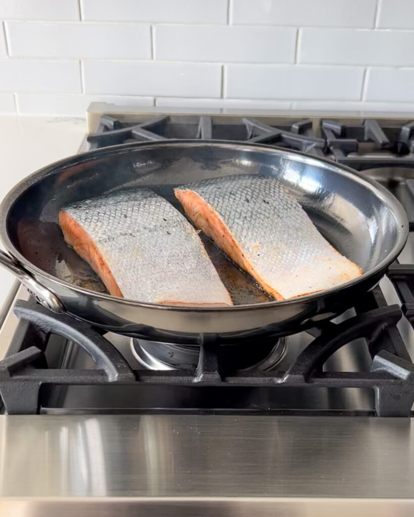 Place the seasoned side of the salmon into the oiled pan.