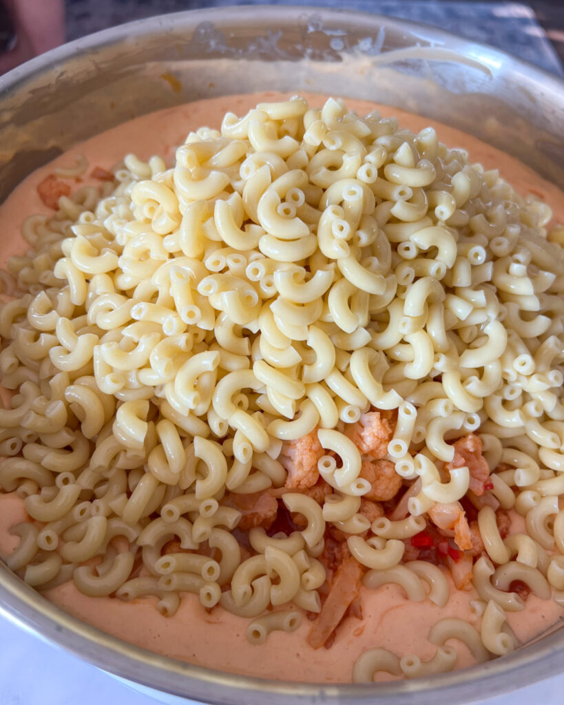 Adding the macaroni to the cheese mixture.