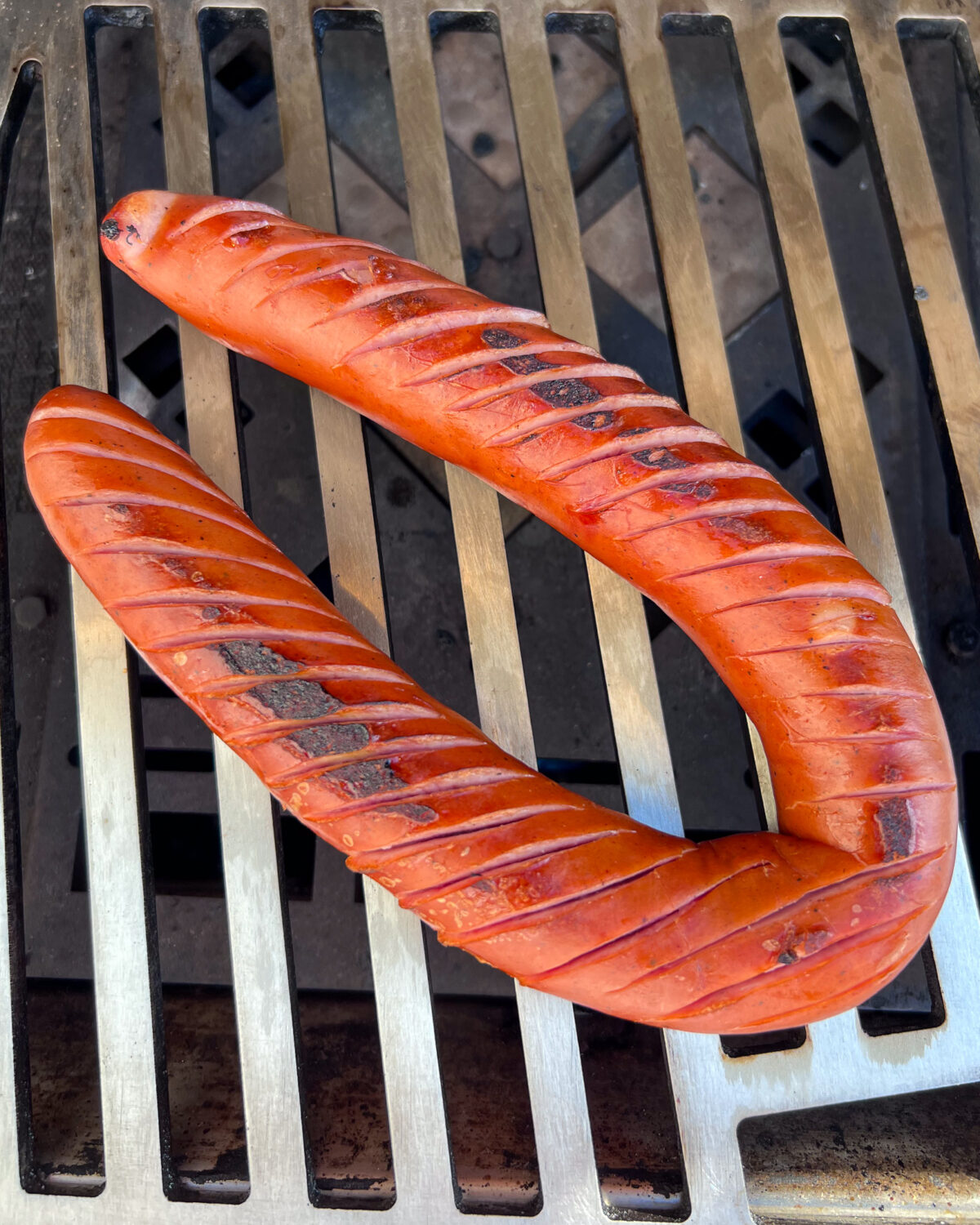 Scored sausage link on the grill.