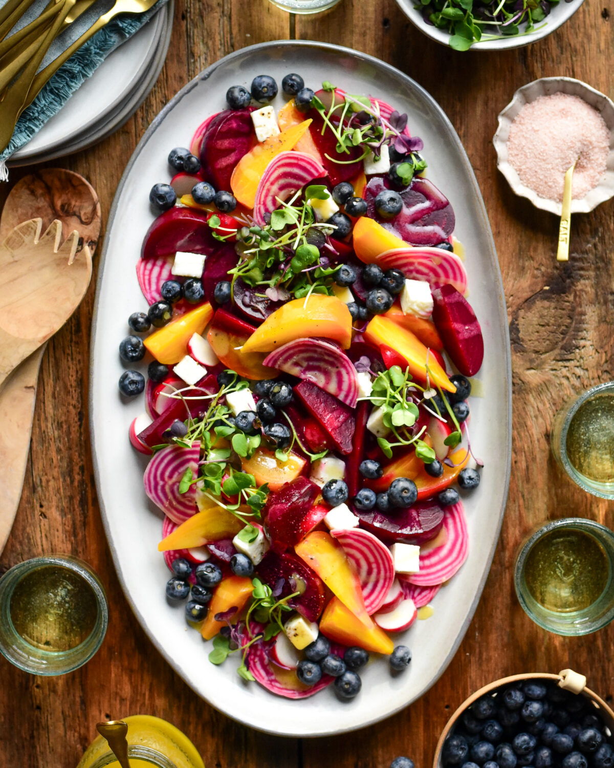 A platter of a sous-vide beet salad with three varieties of beets, radishes, blueberries, micro greens and feta cheese. Served with wine, extra micro greens and blueberries.