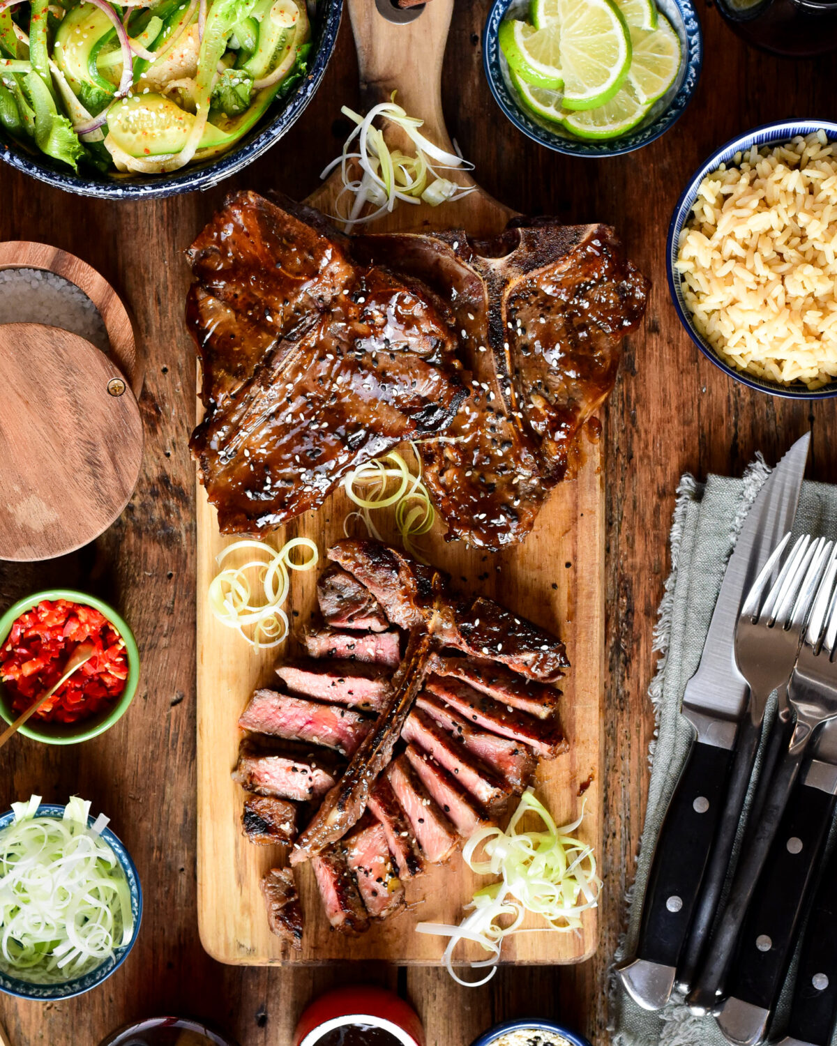 Three Teriyaki T-Bone Veal Chops on a cutting board and one is sliced.