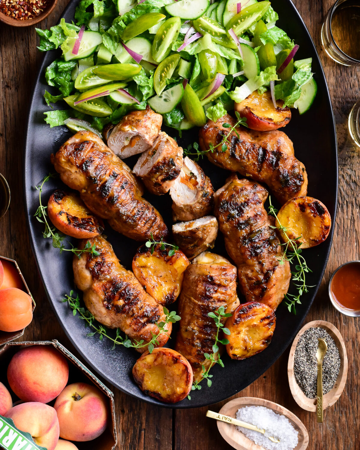 A large platter of (Stuffed) Chicken Breasts with Peach BBQ Sauce and a green salad.