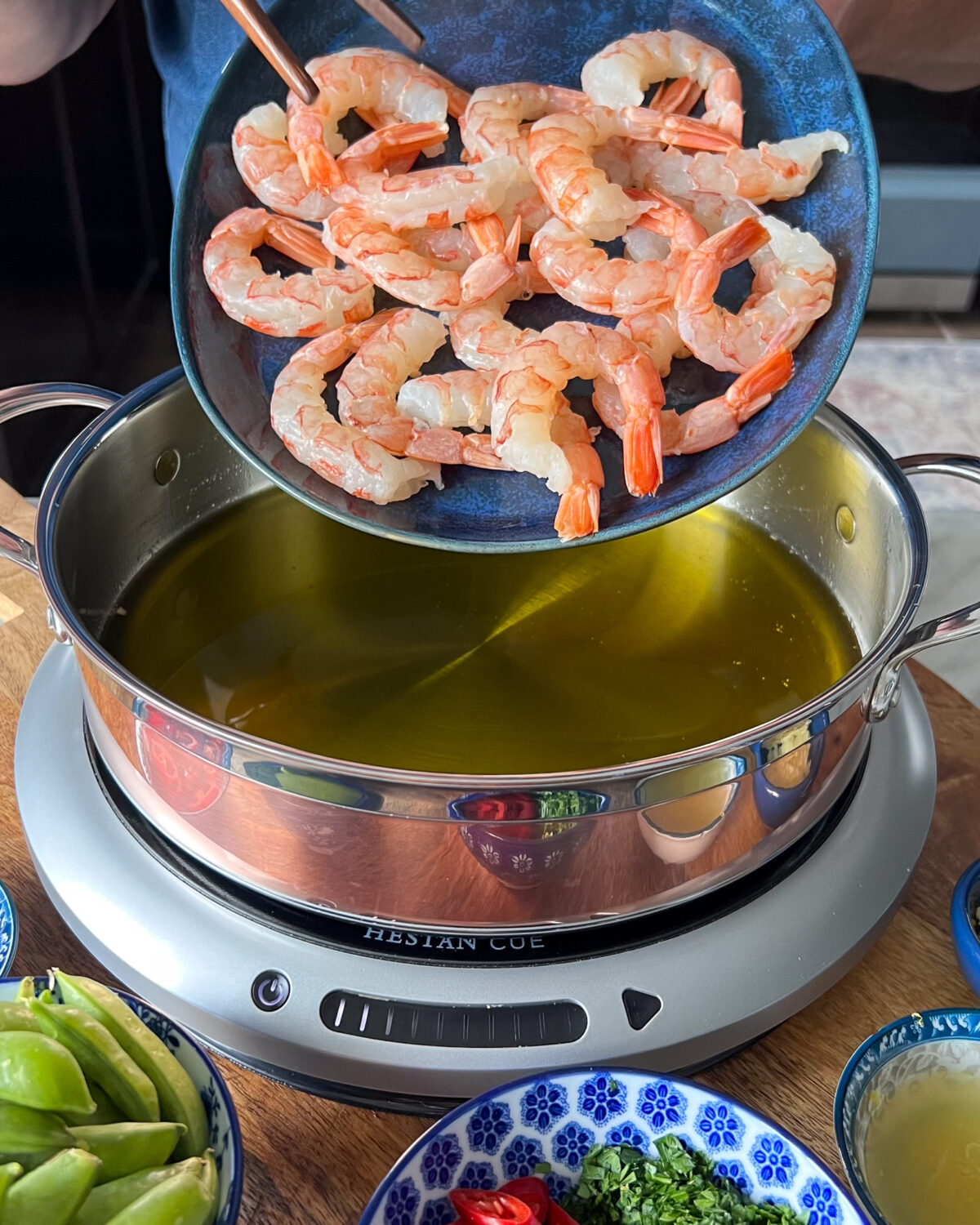 Patted dry shrimp getting added into the the hot garlic oil.