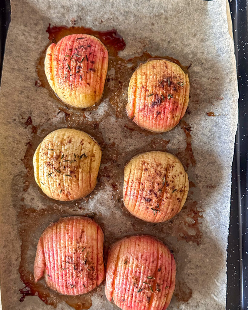 A pan of six hasselback baked apples.