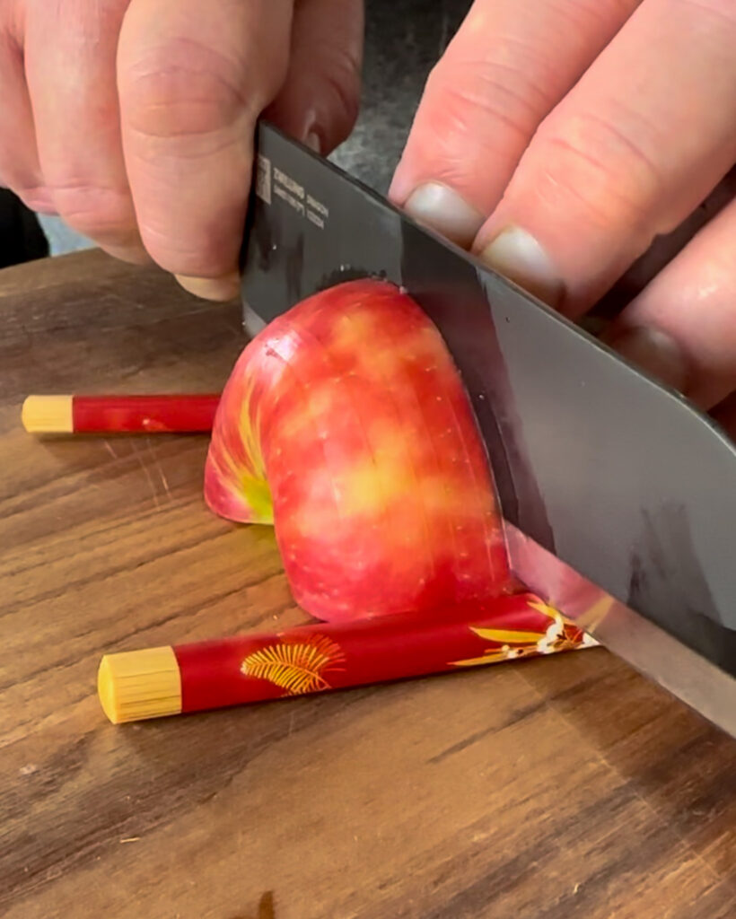 Using two chopsticks as a guard to hasselback apples.