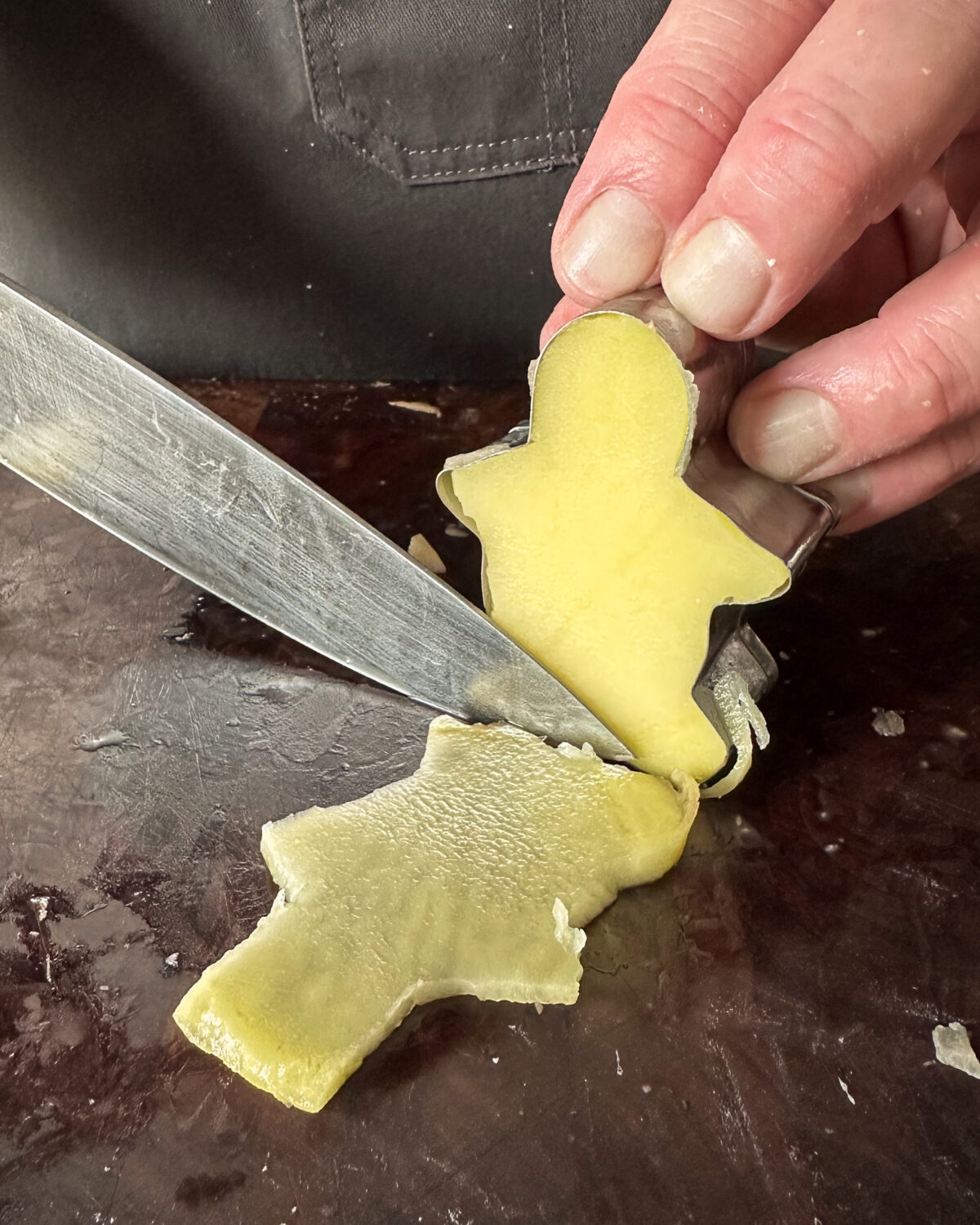 Stand up the gingerbread person and with a sharp knife, carefully slice down both sides of the cutter.