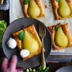 A poached pear baked in a crispy puff pastry shell and served with two scoops of ice cream.