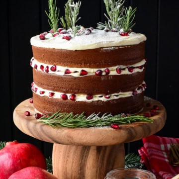 A three layer Honey Cake with Cream Cheese Frosting decorated with rosemary trees and pomegranate arils.