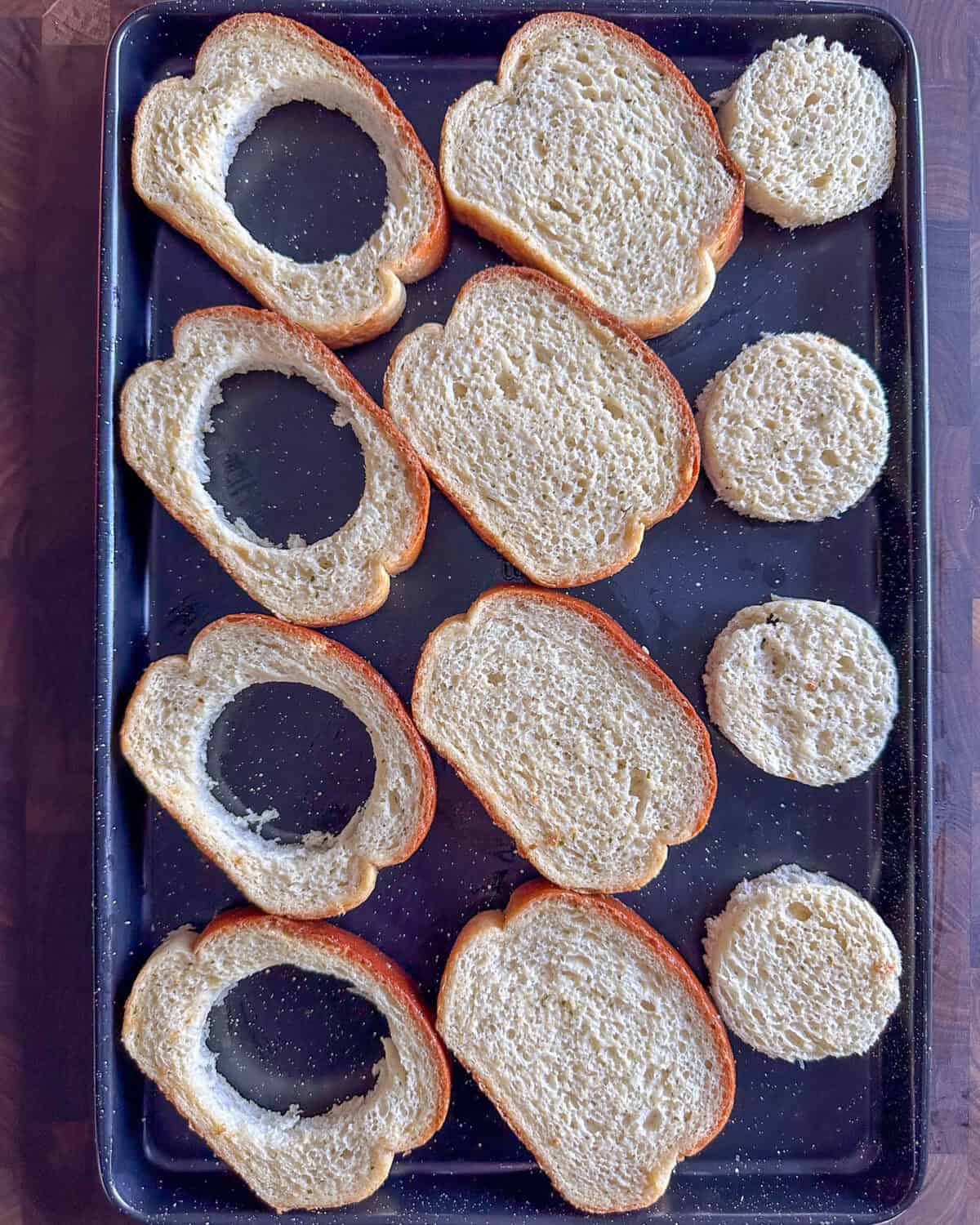 Using a circle cookie cutter, cut out the centre of 4 slices of the Texas toast. Place the circle on the tray.