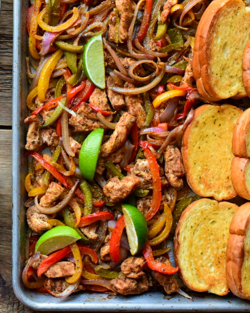 A close up of chicken fajitas with peppers and toasted garlic Texas toast.